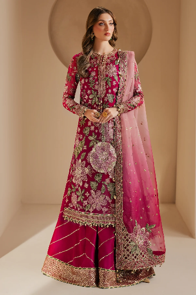 Woman wearing a pink and red embroidered traditional outfit with a matching dupatta against a beige background
